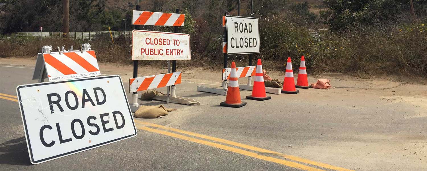 ROAD CLOSED barricades and cones across the road