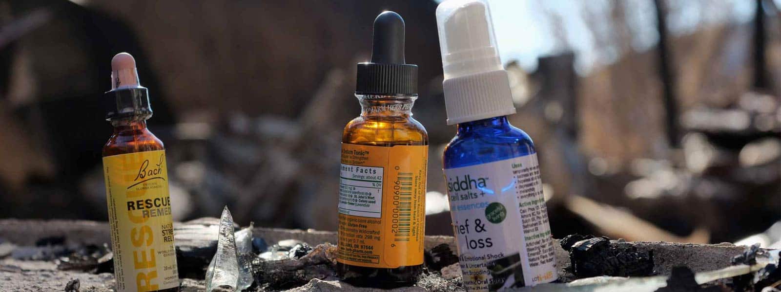Three tincture bottles resting on burned debris